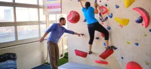 Instruktor pomaže penjačici na boulder stijeni