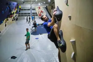Penjač trenira na boulder stijeni u dvorani