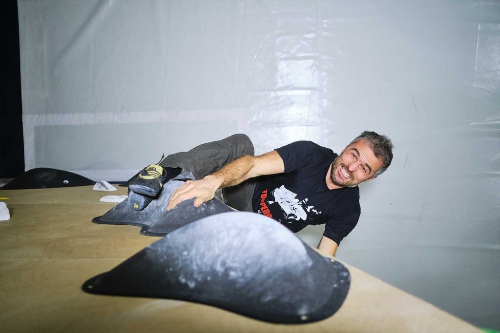 Muškarac vježba penjanje na boulder stijeni