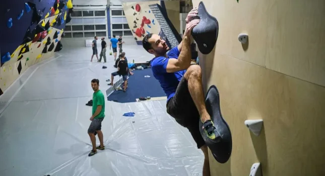 Penjač trenira na boulder stijeni u dvorani