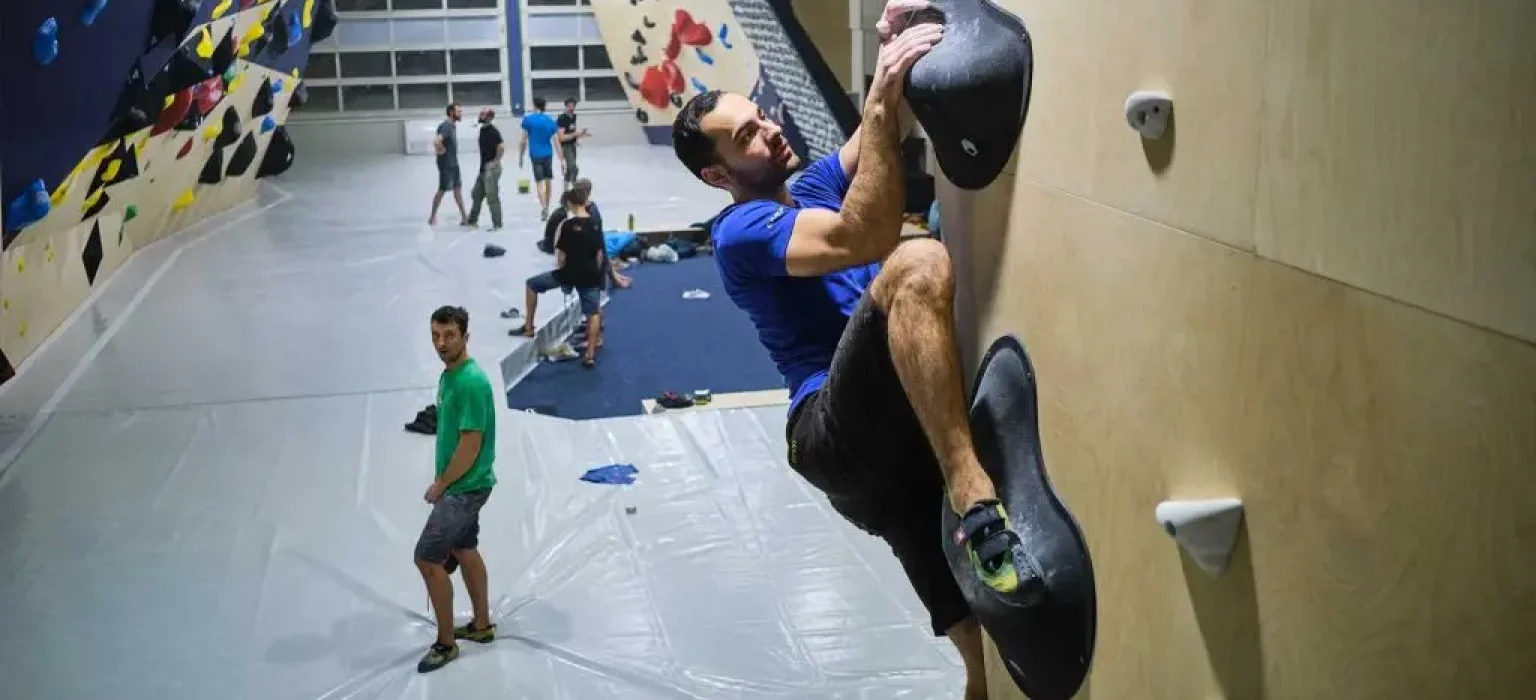 Penjač trenira na boulder stijeni u dvorani