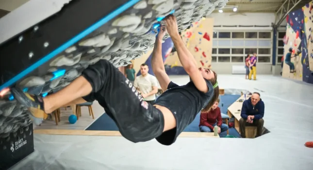 Penjač na boulder stijeni u dvorani